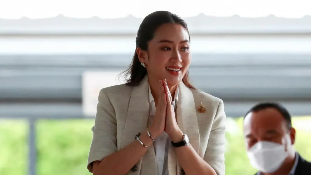 Young woman with folded hands, representing Thailand Prime Minister, showing a respectful and thoughtful gesture